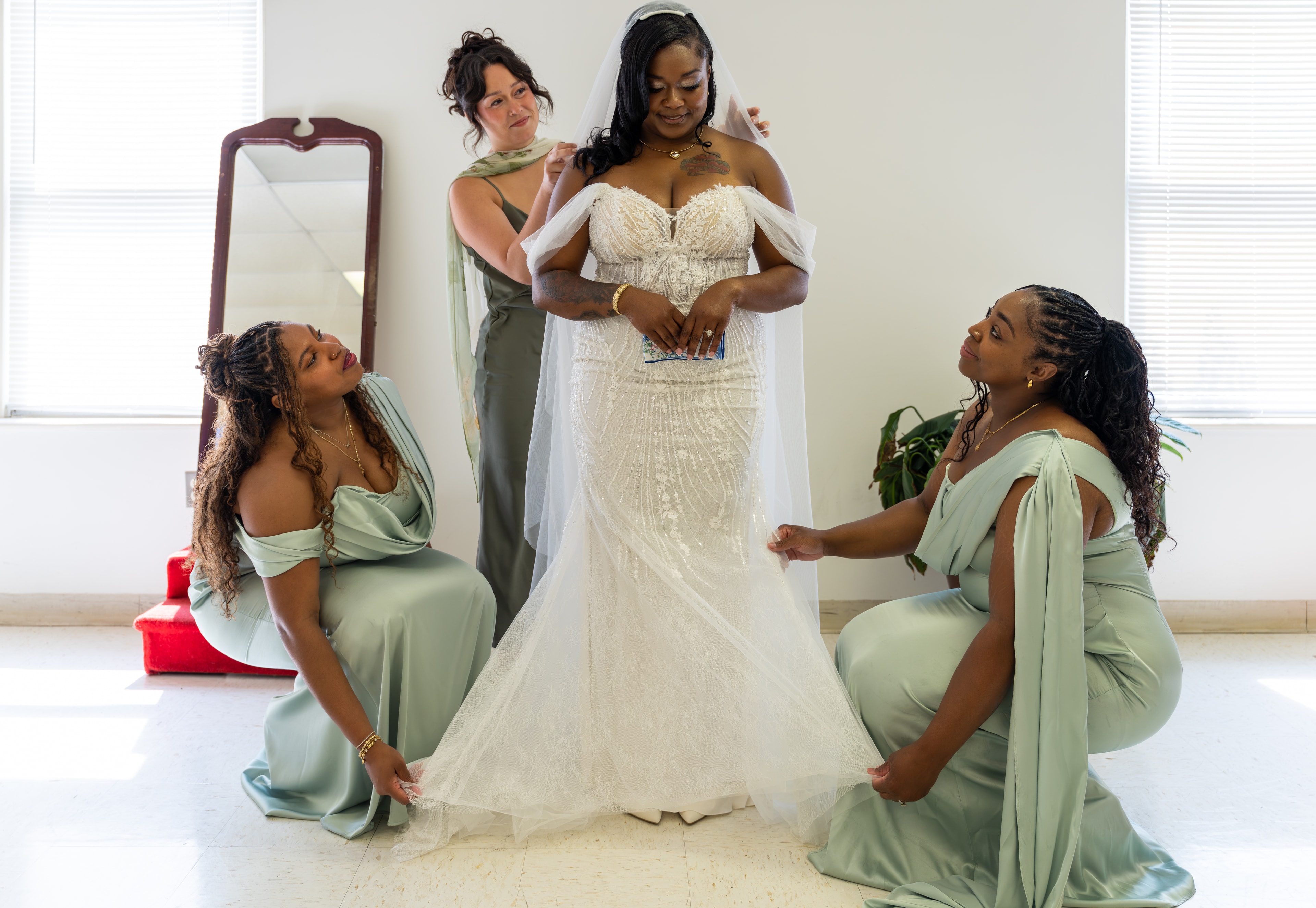 Bridesmaids helping bride into her gown